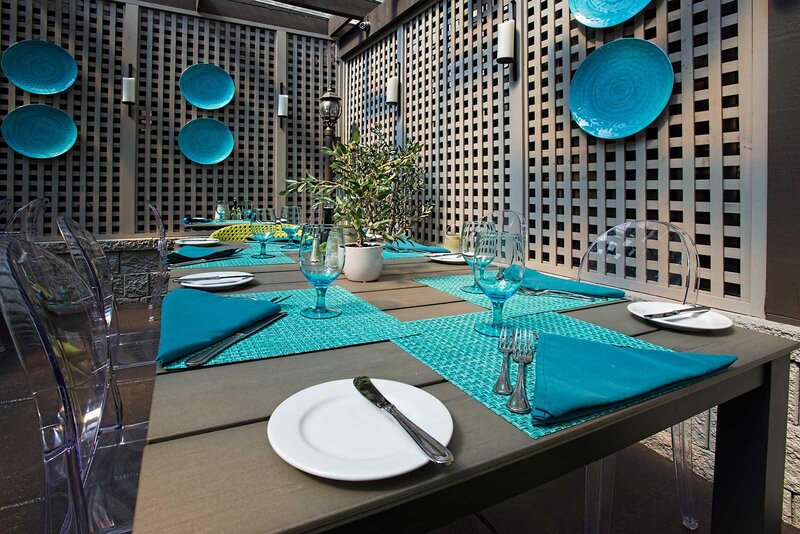 Outdoor patio dining with focus on table with blue table setting