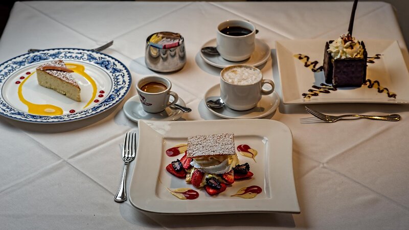 Multiple plated desserts and coffee drinks