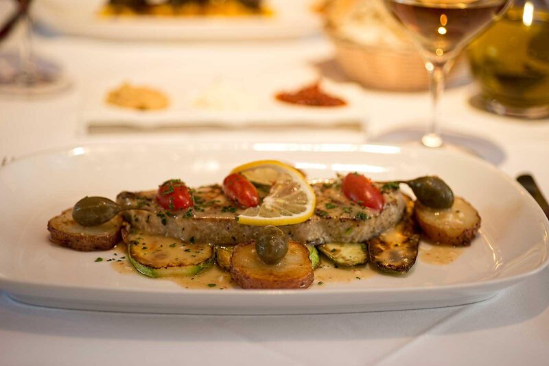 Steak entree topped with cherry tomatoes on top of potatoes