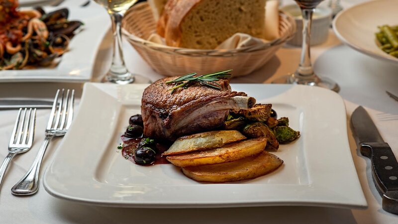 Steak entree with side of potatoes and vegetables